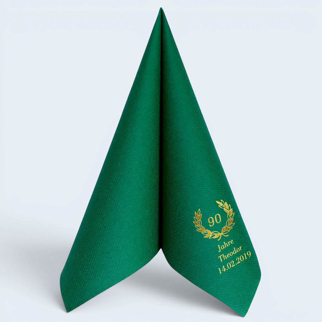 Dunkelgrüne Serviette zum Jubiläum mit personalisiertem Lorbeerkranzmotiv in Gold